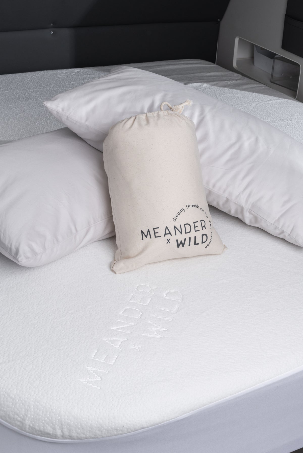 detail of mattress protector, packaging and pillows placed on caravan bed