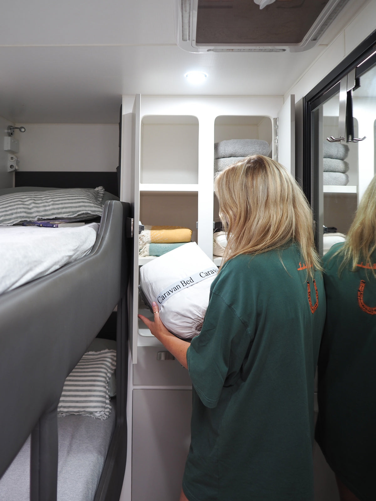 Person putting linen away in caravan cupboard