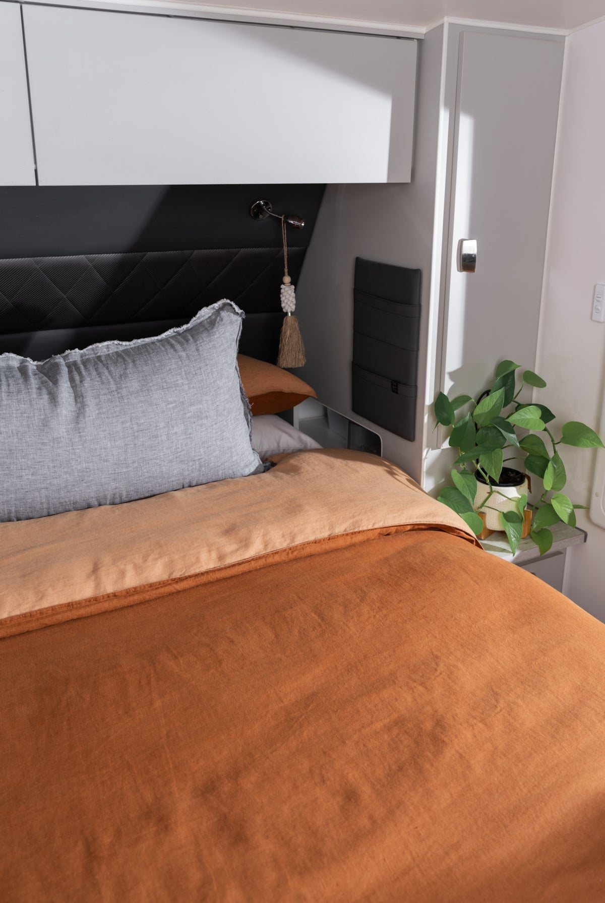 A caravan bed styled with Pier colourway cushion and Ochre Doona cover