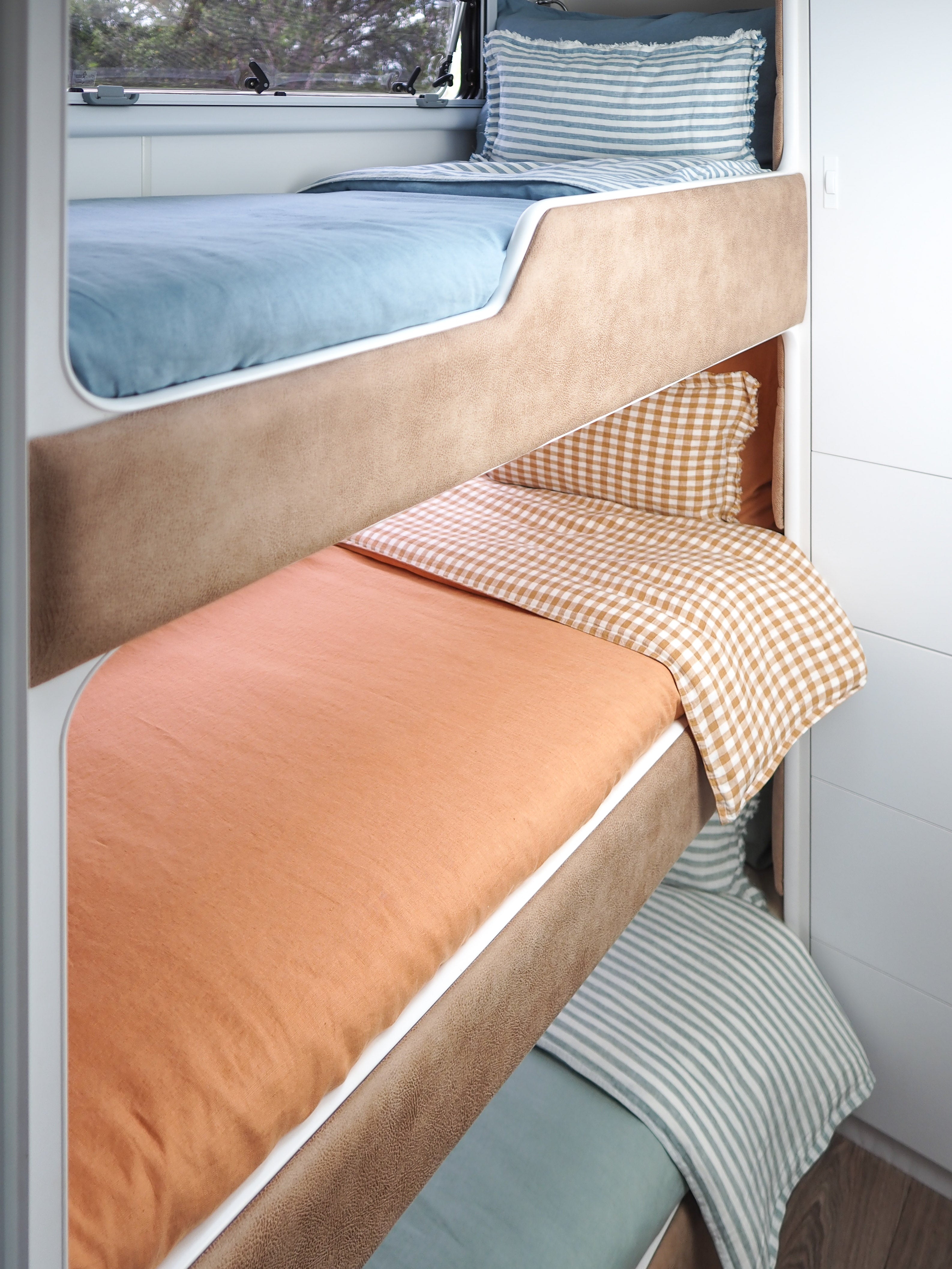 Little Wild Bunk Set in Sea Spray, baby blue and stripe, Copper Dawn Rust and rust check, Coolabah Sage Green and Sage green stripe. European flax linen, on a caravan bunk