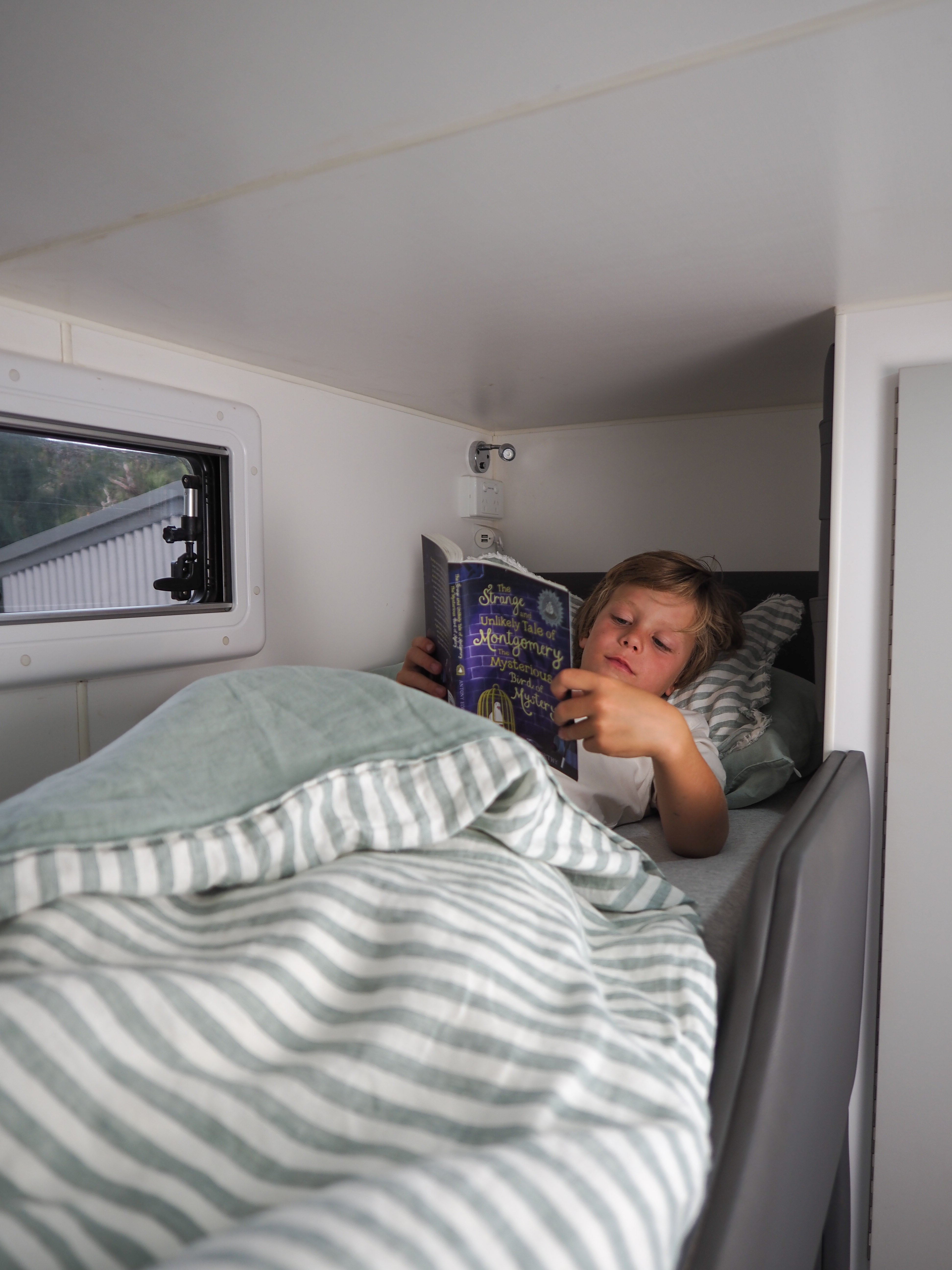 Boy reading book in bunk
