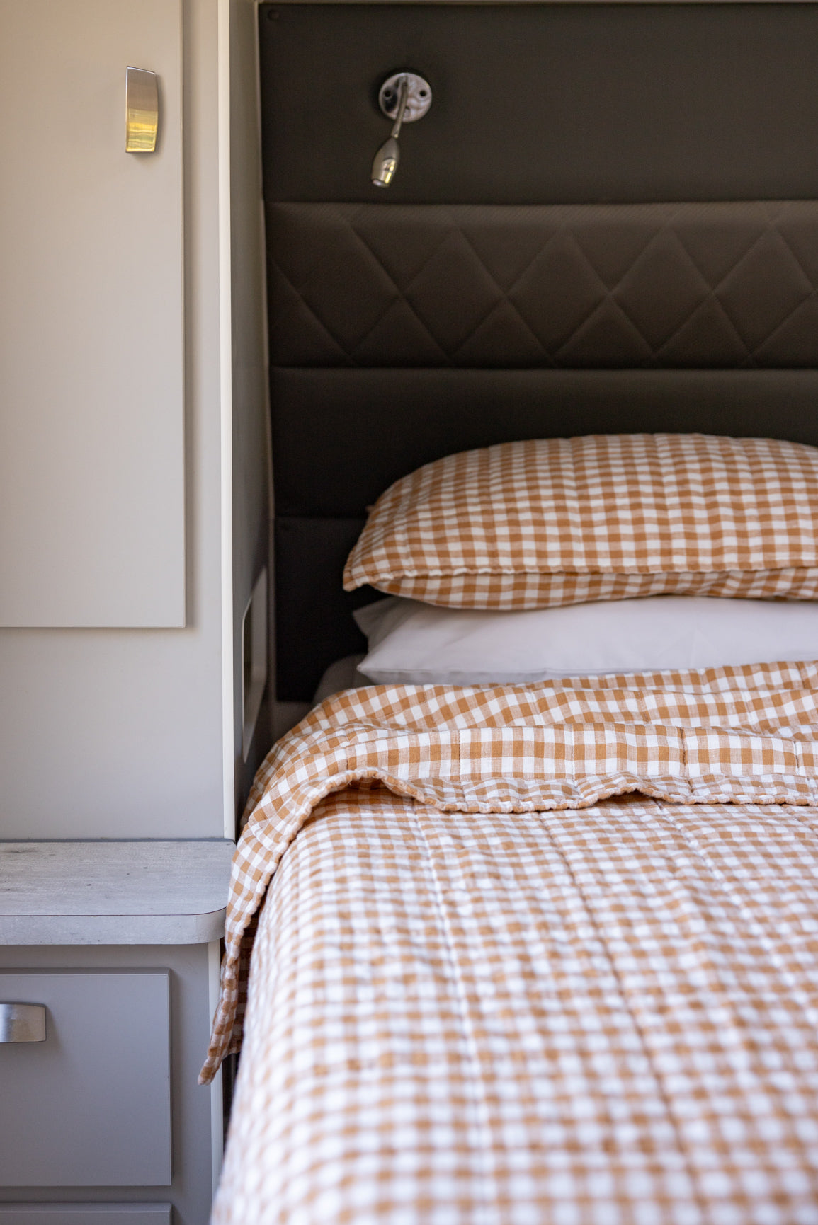 Close up of caravan bed with copper dawn coverlet