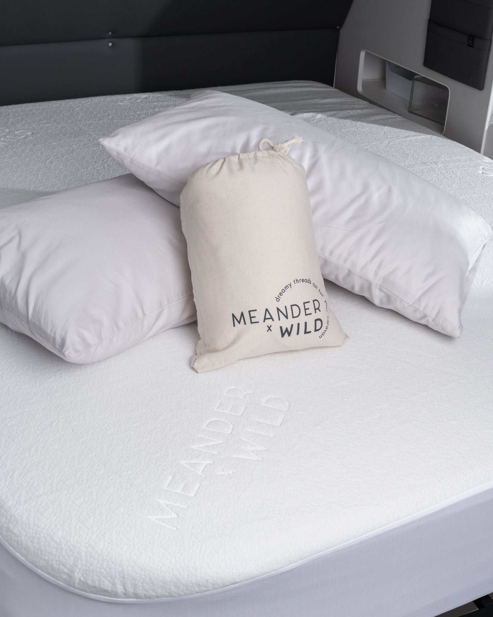 detail of mattress protector, packaging and pillows placed on caravan bed