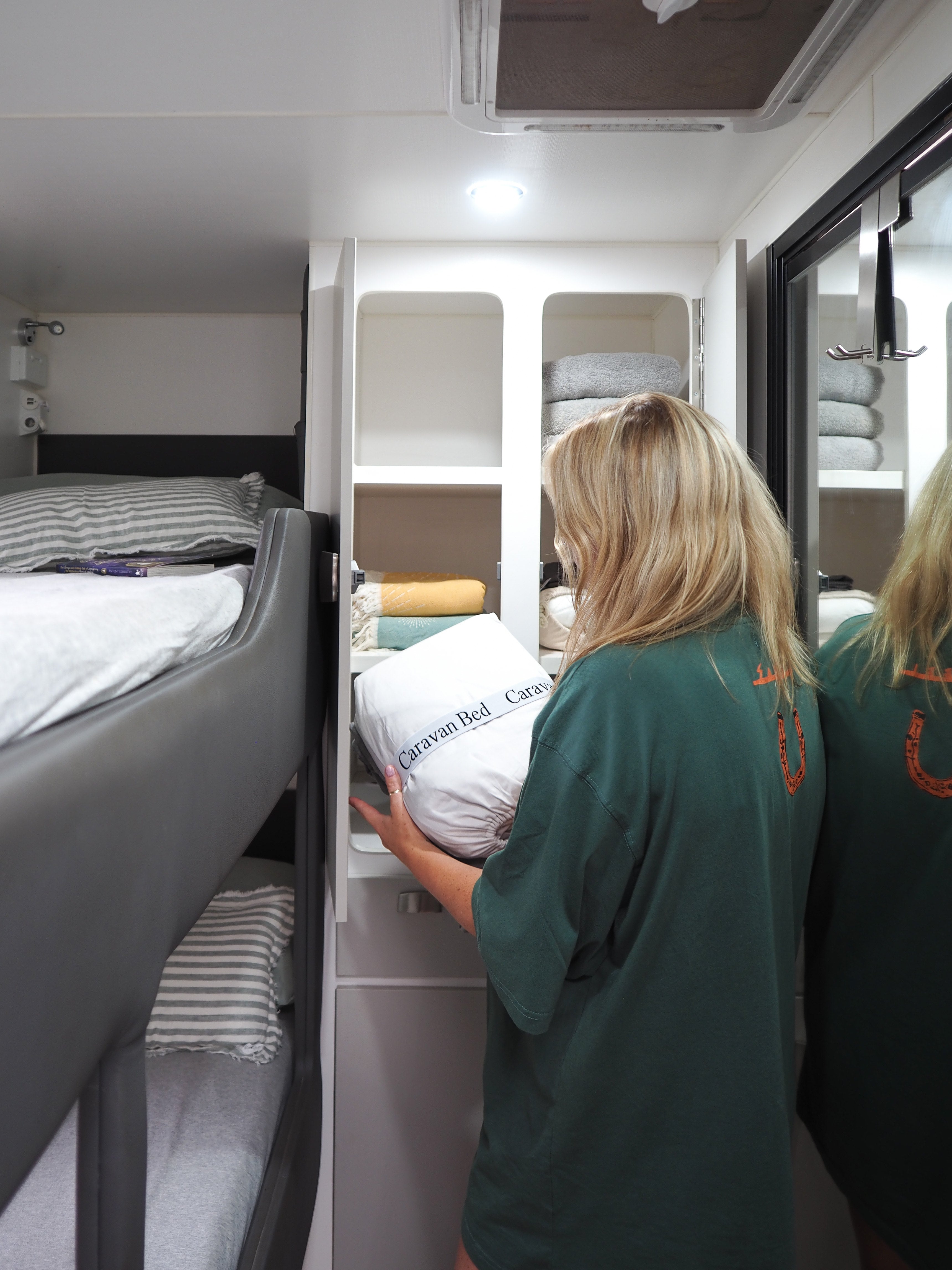 Person putting linen away in caravan cupboard
