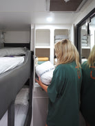 Person putting linen away in caravan cupboard