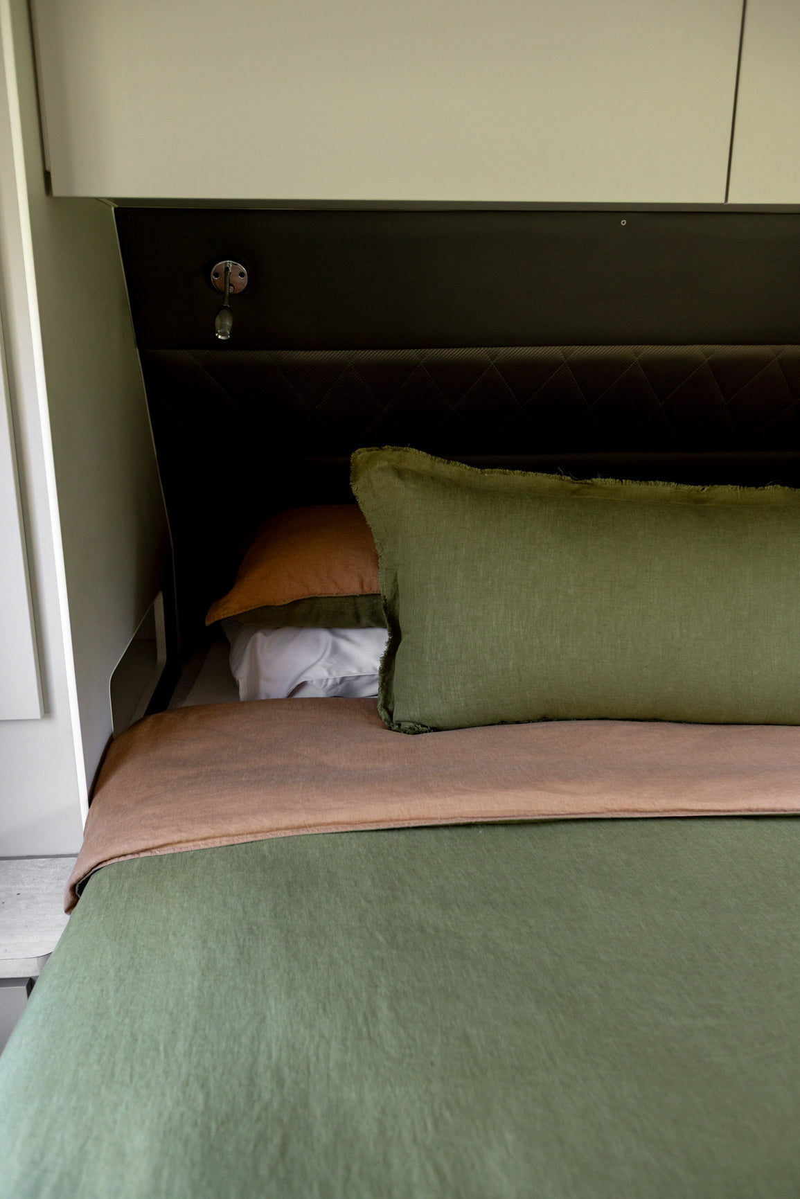 forest green and brown bedding close up in caravan 